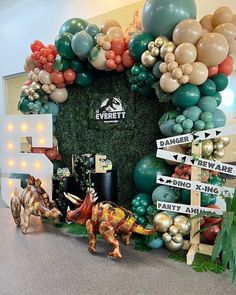 there is a fake dinosaur in front of the entrance to an event with balloons on it