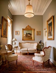 a living room filled with furniture and paintings