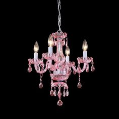 a pink chandelier hanging from a chain with three lights on each arm and two candles in the middle