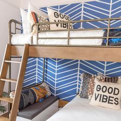 a bunk bed in a bedroom with blue and white wallpaper on the walls behind it