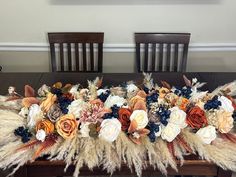 the table is decorated with flowers and feathers