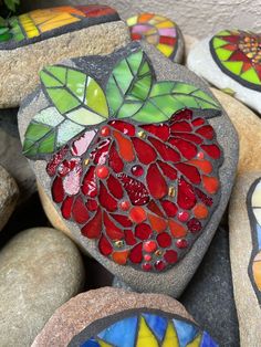 some rocks with different designs on them and one has a heart in the middle, surrounded by leaves