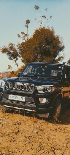 a black jeep is parked in the dirt