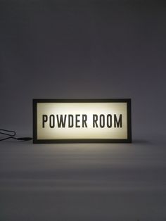 a sign that reads powder room on the floor in front of a wall with wires