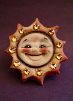 "Please allow 2 - 3 weeks for delivery. How fun is this happy, sunshiny, smiling tac pin?! It is hand sculpted, hand painted, and made of porcelain. Each one is unique and measures approx. 2\" high and 2\" wide. Eleven gold Swarovski Crystals embellish this happy little sun for loads of sparkle. A whimsical and unique piece of jewelry!" Polymer Clay Sun, Handmade Sun-shaped Necklace For Gifts, Sun With Face Art, Clay Moon Face, Ceramic Sun Face, Dental Ceramics, Ceramic Tile Bathrooms, Porcelain Jewelry