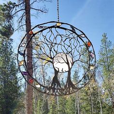 a metal sculpture hanging from the side of a tree