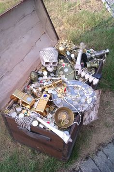 an old trunk is filled with jewelry and knick - knacks on the ground