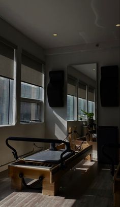 an empty bed sitting in the middle of a room with lots of windows on both sides