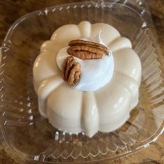 two pecans sitting on top of a cake in a glass dish with frosting