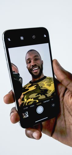 a person holding up a cell phone to take a selfie with the same image on it