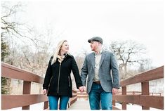 a man and woman walking across a bridge holding hands