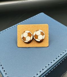 two small soccer balls are sitting on top of a piece of leather, which is attached to a clipboard