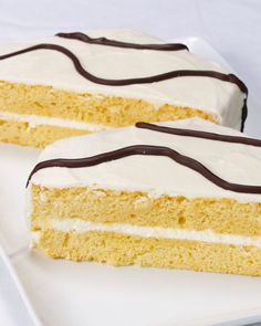 two slices of cake on a plate with white frosting and chocolate icing, sitting next to each other