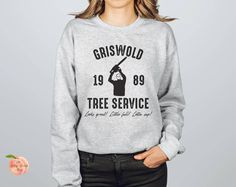 a woman wearing a sweatshirt with the words griswold tree service on it