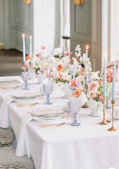 the table is set with flowers and candles