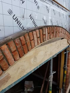 an unfinished brick wall under construction with scaffolding