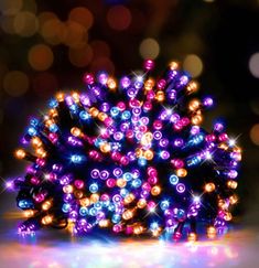 a close up of a bunch of lights on a table with blurry lights in the background