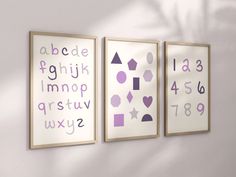 three purple and white wall hangings with numbers, shapes, and letters on them