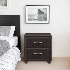 a bed room with a neatly made bed and two pictures on the wall