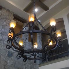 a large chandelier hanging from the ceiling in a room with stone walls and beams