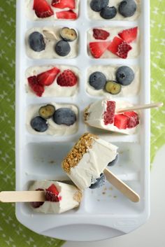 an icebox with strawberries, blueberries and raspberries on it is ready to be eaten