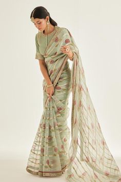 Smoke green silk organza saree with all over metallic stripe pattern, contrast floral hand block print and zardozi embroidered border. Paired with padded blouse with all over pintuck details and floral zardozi embroidered panels.
Components: 2
Pattern: Printed and Embroidered
Type Of Work: Floral Hand Block Print and Zardozi Work
Neckline: Round Neck
Sleeve Type: Half Sleeves
Fabric: Silk Organza
Color: Green
Other Details: 
Contrast saree border
Embroidered sleeve borders
Blouse Closure: Front Floral Saree Blouse, Organza Sari, Floral Saree, Block Print Saree, Organza Saree, Silk Organza, Printed Silk, Printed Sarees, Green Silk