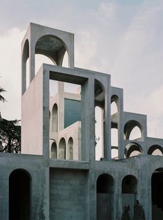 the building is made out of concrete and has arches on each side that are connected to other structures