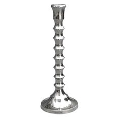 a tall metal vase with spikes on the top and bottom, sitting in front of a white background