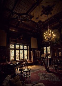 an old fashioned living room with chandelier and stained glass windows