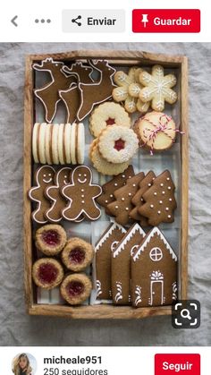 a wooden box filled with lots of different types of cookies and pastries on top of a table