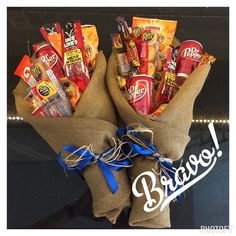 two burlocks filled with snacks sitting on top of a black table next to a blue ribbon