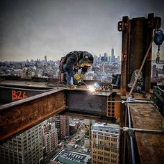 a man working on the roof of a building with cityscape in the background