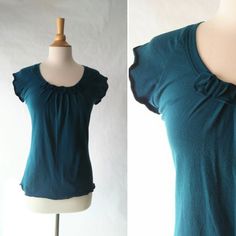 "Womens short sleeve tshirt - Little bits tee. This is a cute little tee with raglan cap sleeves. It has pleats in front with little circular bits stitched on top. It is loose and flowy and is made with my favorite soft stretchy cotton jersey knit. Length from shoulder to hem size Small is 24\", length increases 1/2\" each size up (note the length can be adjusted as needed) Shown in Teal See Swatch Chart in the last photo for available Color options. Garments are Made To Order Please allow 7-10 Stretch Cotton Cap Sleeve Top, Cotton Cap Sleeve Top, Trendy Tops With Relaxed Fit And Cap Sleeve, Casual Fitted T-shirt With Cap Sleeves, Fitted Cotton Top With Cap Sleeves, Relaxed Fit Cap Sleeve T-shirt For Summer, Fitted Cotton Blouse With Short Sleeves, Summer Cap Sleeve Tops, Fitted Cotton Short Sleeve Top With Scoop Neck