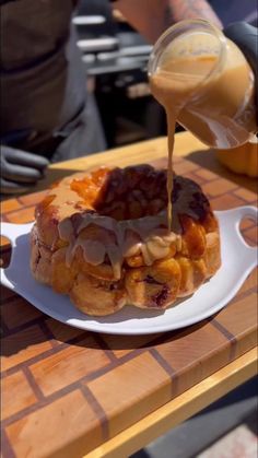 a person pouring syrup on top of a waffle