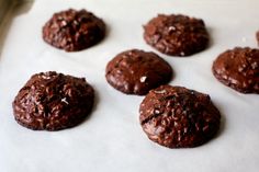 chocolate cookies are lined up on a baking sheet