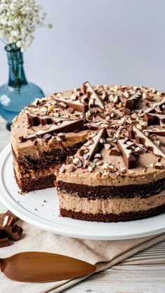 a chocolate cake on a white plate with one slice cut out