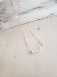 * Simple and sweet, great for layering with other necklaces for a feminine touch. Would also be beautiful for bridesmaids or a bride! * White freshwater pearls are wrapped in a softly curved bar and finished with a shimmery and dainty chain. * Cable chain is delicate yet strong and finished with an oval lobster clasp. * Made from top quality water proof materials. No green skin or color fading. * Nickel free. ~M A T E R I A L S ~ Choose from- * 925 Sterling silver *14k Gold fill *14k Rose gold f Rose Gold Necklace With Delicate Chain For Bridesmaid, Rose Gold Delicate Chain Necklace For Bridesmaid, Dainty Rose Gold Necklace For Bridesmaids, Elegant 14k Gold-filled Bar Necklace, Elegant 14k Gold Filled Bar Necklace, 14k Rose Gold Filled Necklaces With Pearl Pendant, Rose Gold 14k Gold-filled Necklace With Pearl Pendant, Feminine Rose Gold Necklace With Pearl Drop, Feminine Rose Gold Necklace With Pearl Chain