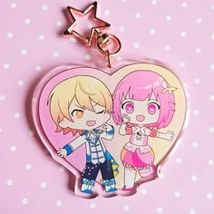 two anime characters are standing next to each other on a heart shaped keychain