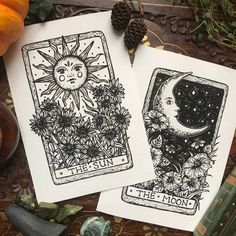 two tarot cards with the sun and moon on them, surrounded by autumn leaves