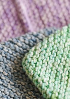 a close up view of a green and blue crocheted cloth with a button