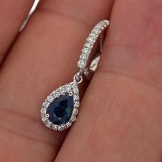 These 18 karat white gold earrings have 2 matching 7 x 5 natural blue sapphires weighing 2.11 carats total weight. On the clip and in the halo are 52 round diamonds weighing .40 carats total weight and graded G/H in color and VS2 in clarity. The l... Sapphire Halo Drop Earrings, White Gold Pear-shaped Halo Jewelry, Pear-shaped Halo White Gold Jewelry, Teardrop Sapphire Jewelry With Halo Setting, White Gold Teardrop Halo Jewelry, White Gold Sapphire Earrings With Halo Setting, Blue Halo Platinum Jewelry, Diamond Halo Earrings, Halo Diamond Earrings