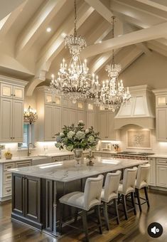 a large kitchen with an island and chandelier hanging from it's ceiling