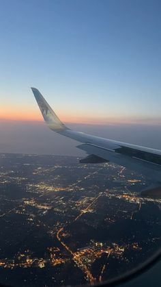 the wing of an airplane flying over a city at night