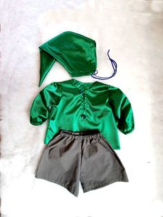 a green and grey outfit is laying on a white surface next to a pair of shoes