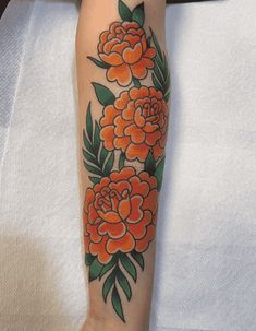 an orange flower tattoo on the arm