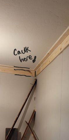 a room that has some tools on the floor in front of it and graffiti written on the wall