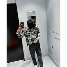 a man taking a selfie in front of an open bathroom door with his cell phone