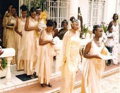 a group of women in yellow dresses standing on steps next to each other with flowers