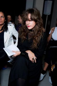 two women sitting next to each other at a fashion show