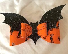 an orange and black bow with bats on it